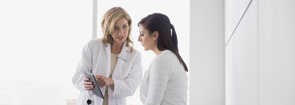 Doctor showing a woman data on a tablet